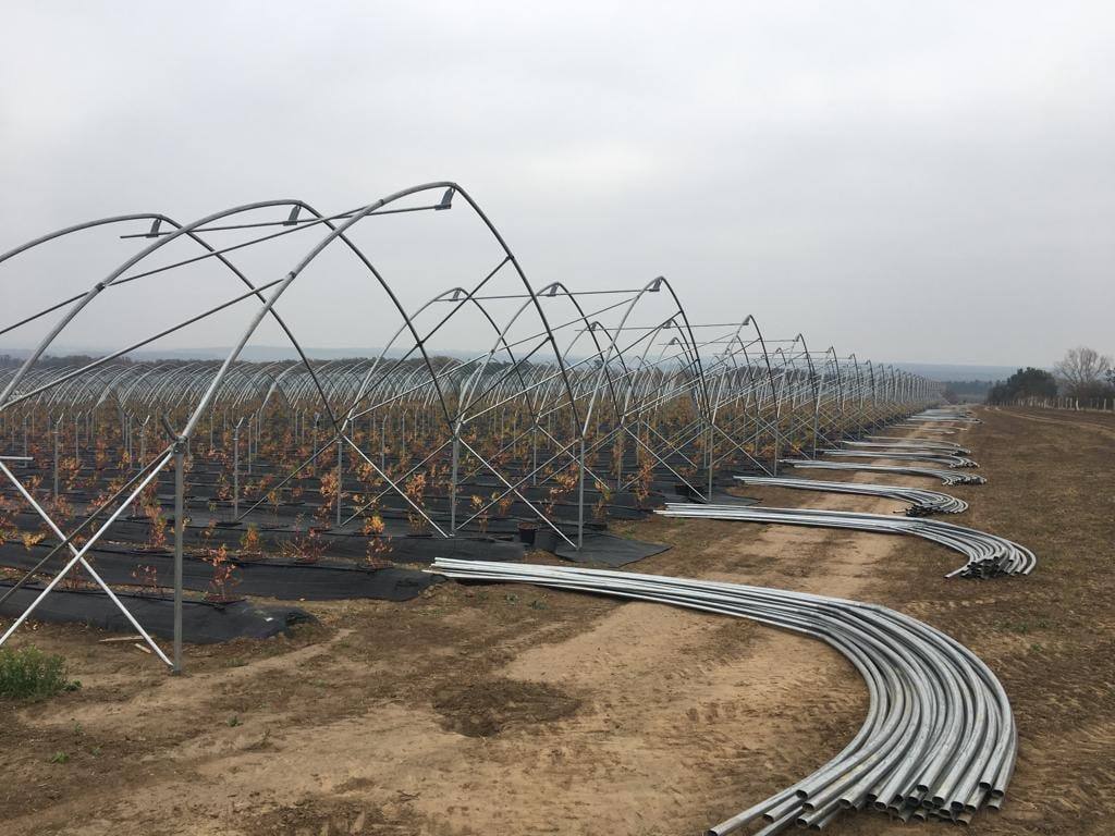 Wręgi ułożone na ziemi obok częściowo postawionej konstrukcji tunelu zblokowanego